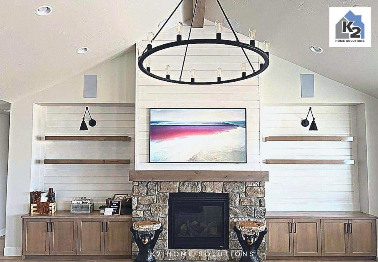 Living room with a fireplace, built-in shelving, and a large chandelier.