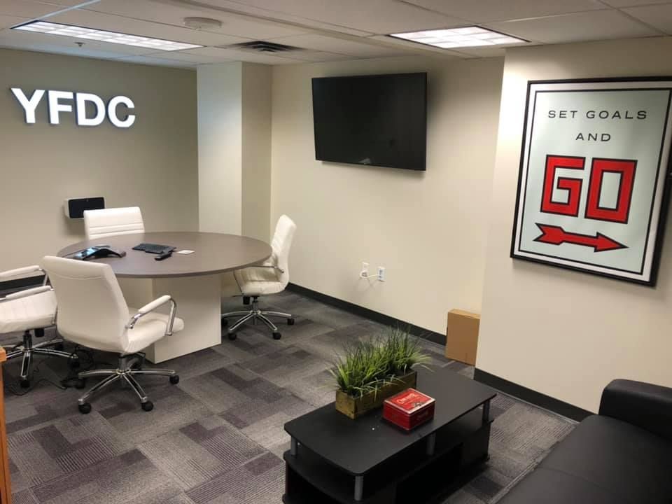Office space with a round table, chairs, TV, and 