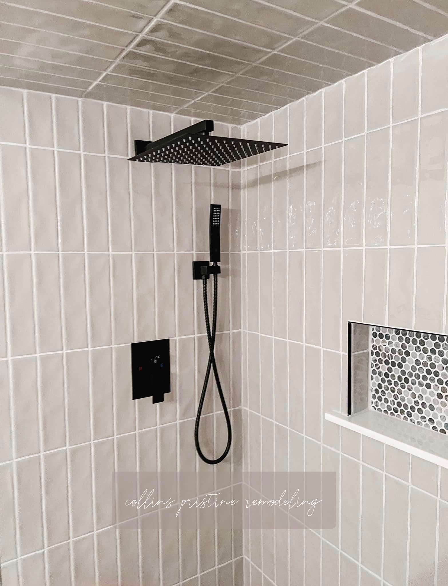 Modern shower with white tiles, black fixtures, and a square rain showerhead.