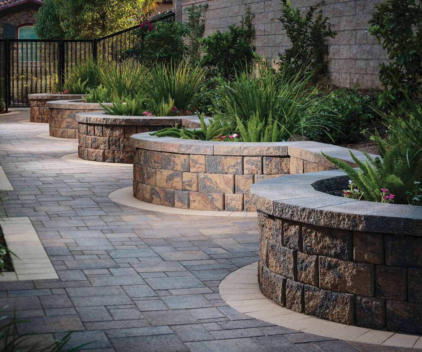 A row of stone planters on a brick walkway