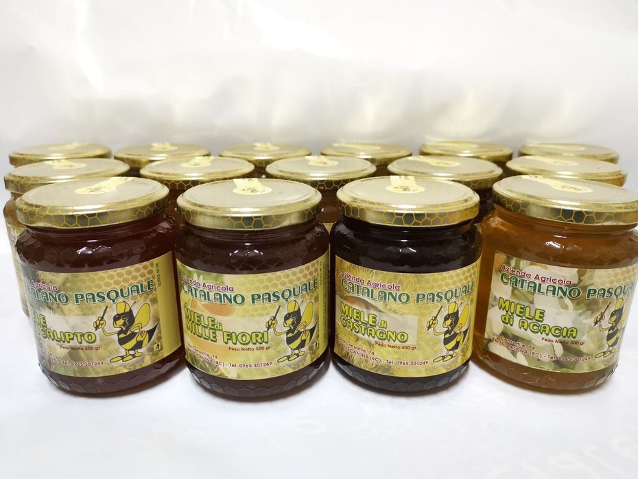 Scatola di cartone aperta contenente 12 barattoli, chiusa con sigilli o nastro adesivo giallo.