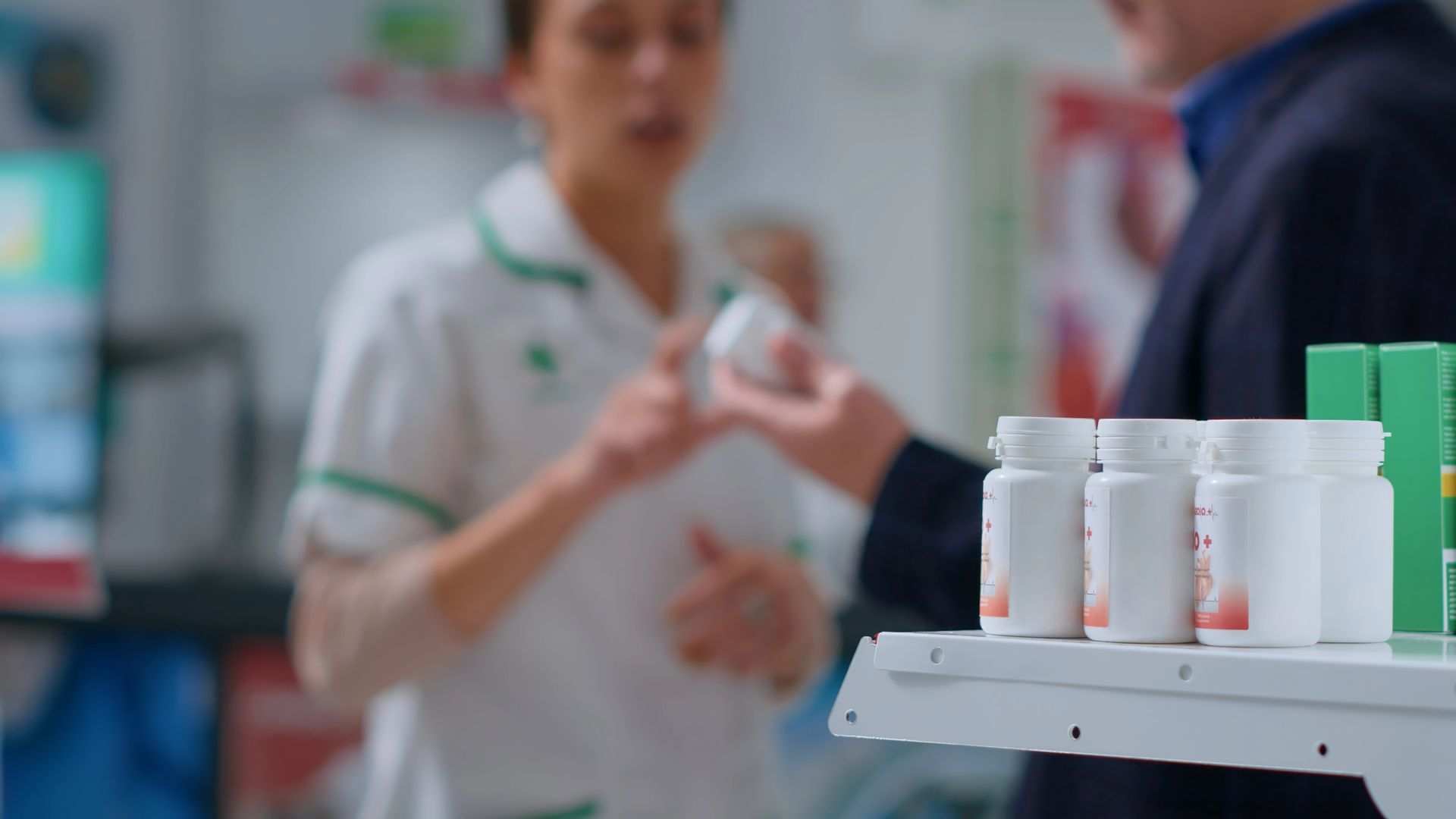 Il farmacista porge il flacone del farmaco al cliente al bancone della farmacia.