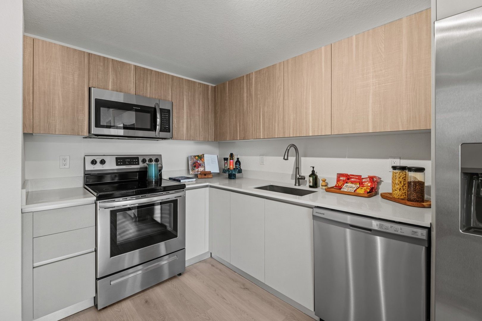 A kitchen with stainless steel appliances and wooden cabinets.