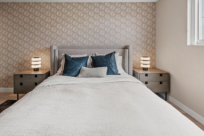 A bedroom with a bed , nightstands , and a window.