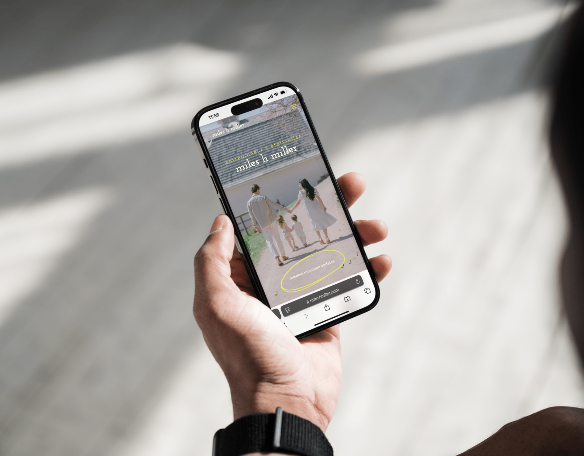 A person is holding a cell phone with a picture of a man on the screen.