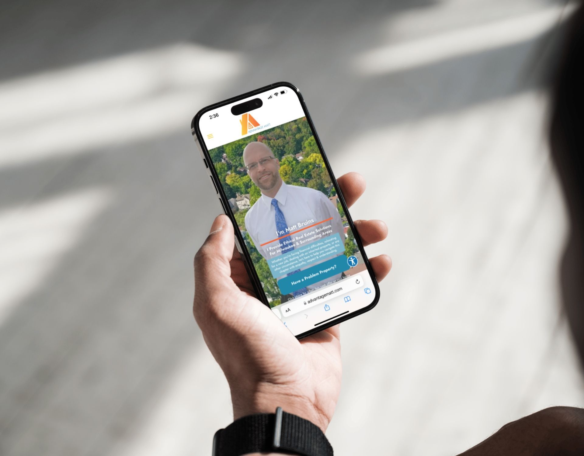 A person is holding a cell phone with a picture of a man on the screen.
