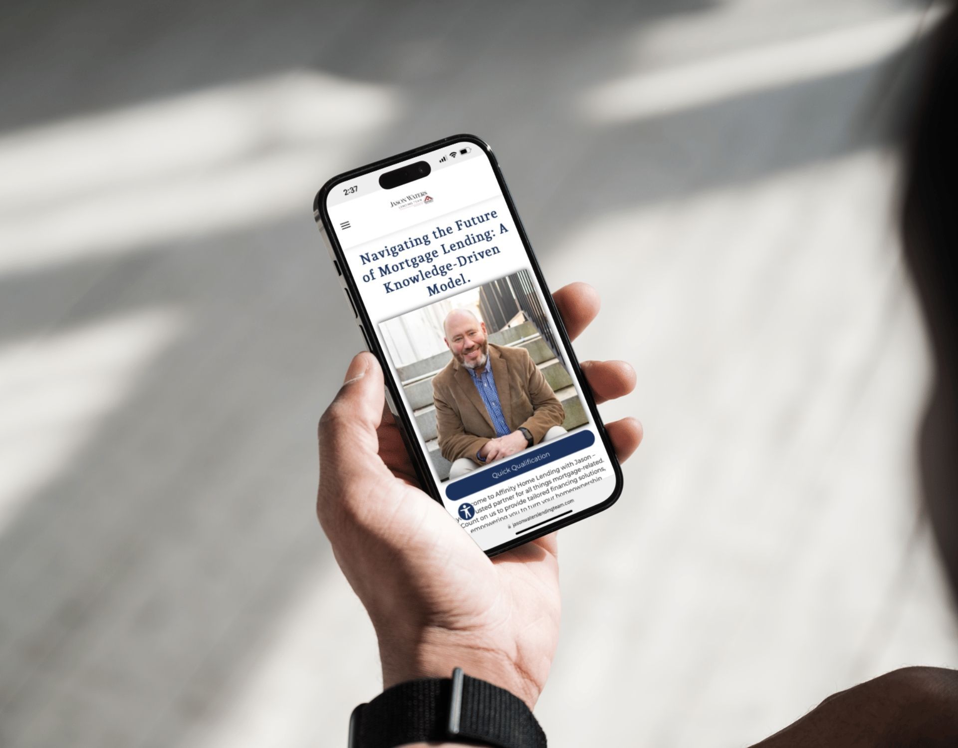 A person is holding a cell phone with a picture of a man on the screen.