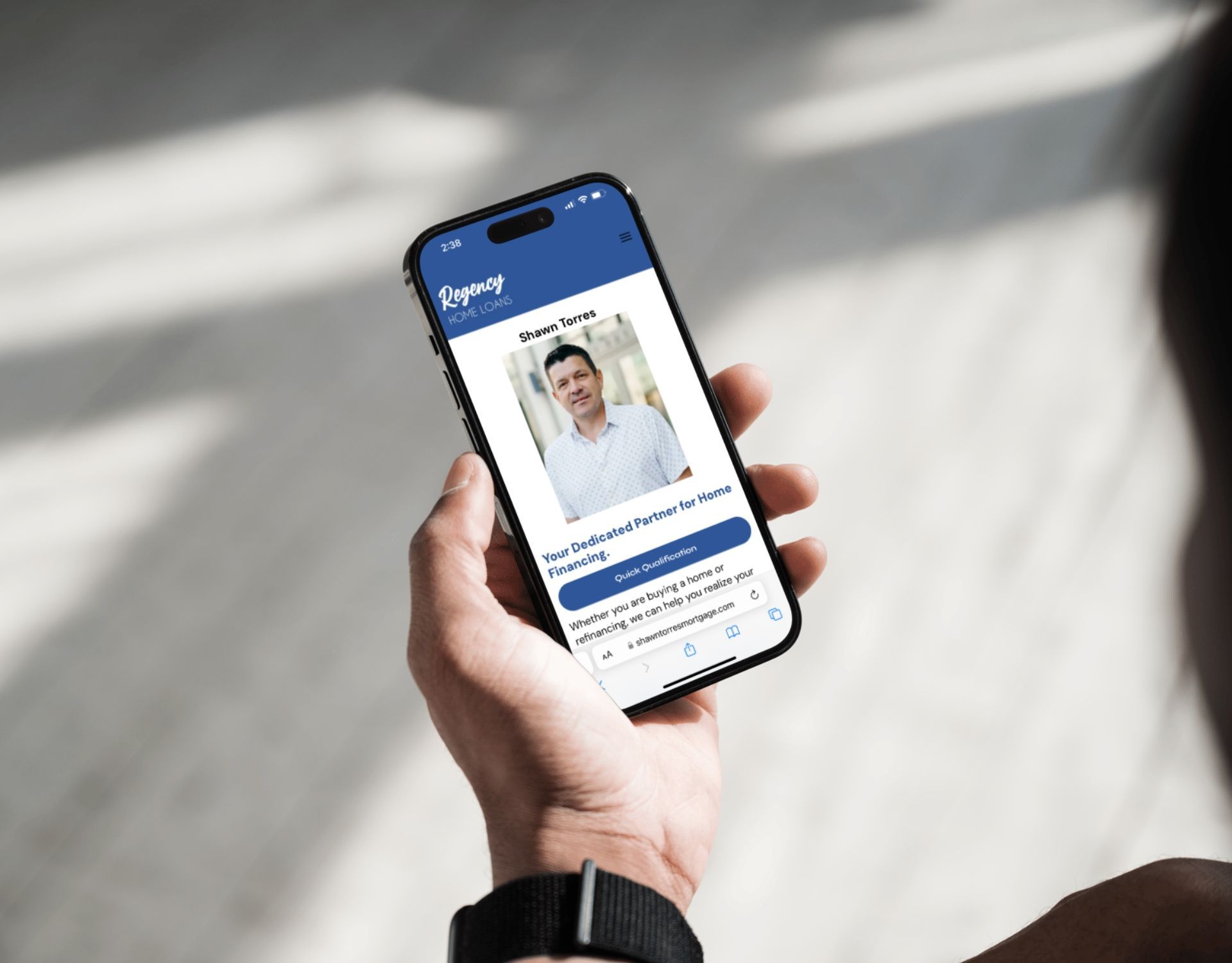 A person is holding a cell phone with a picture of a man on the screen.