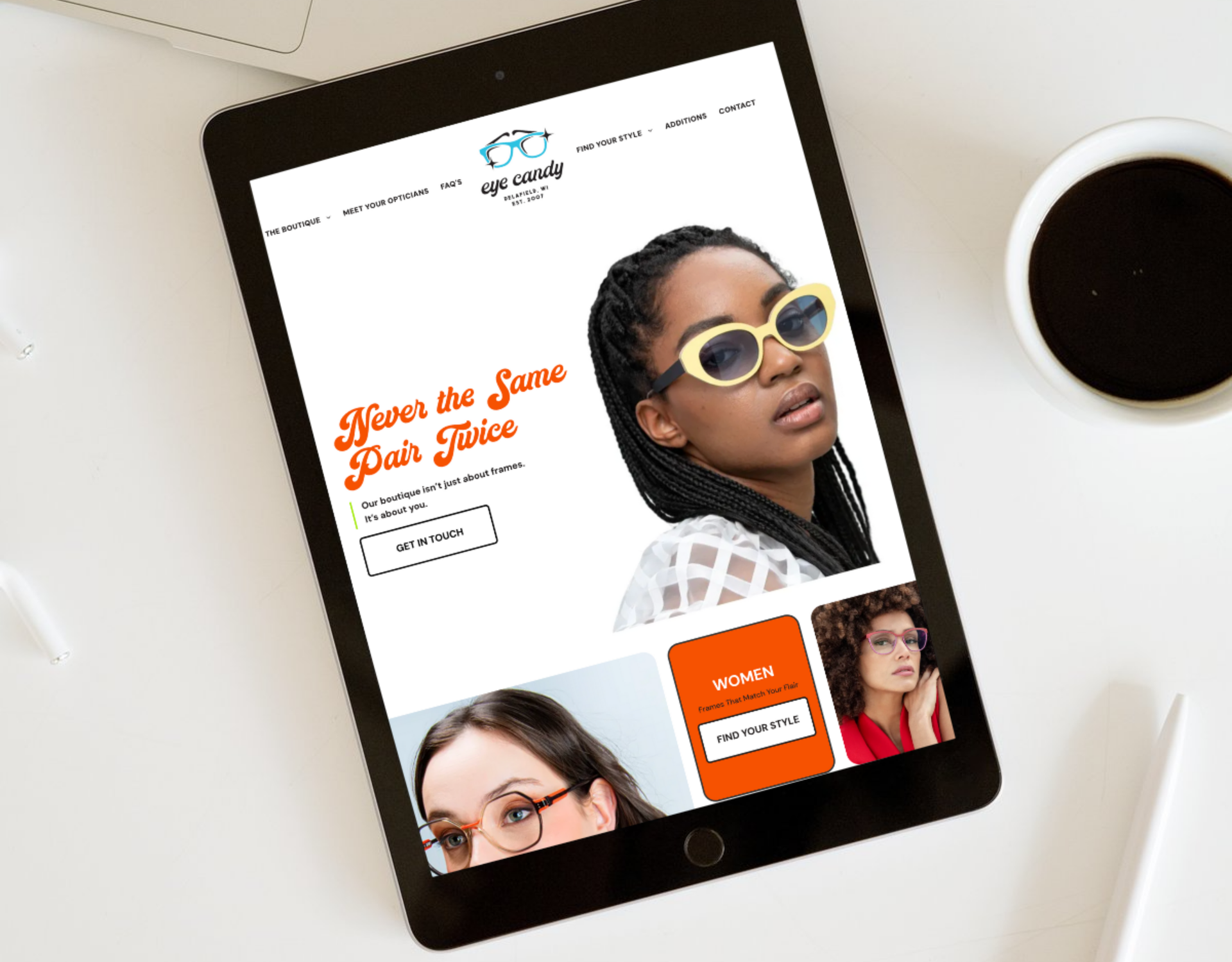 A tablet is sitting on a table next to a cup of coffee.