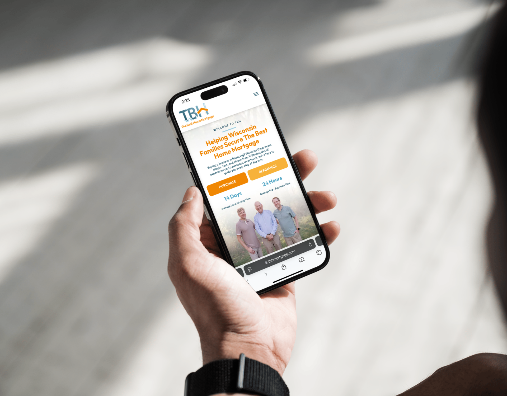 A person is holding a cell phone with a picture of a man on the screen.