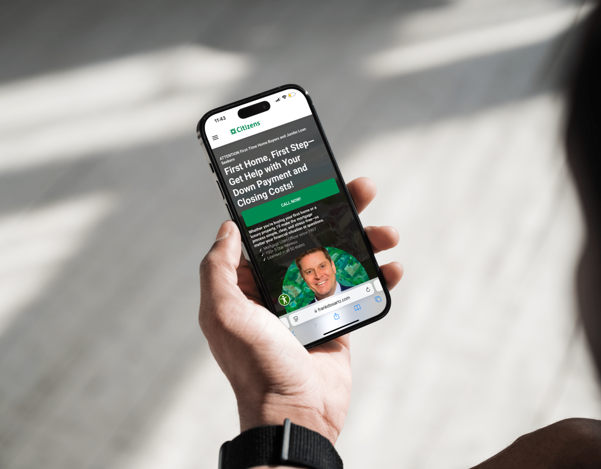A person is holding a cell phone with a picture of a man on the screen.