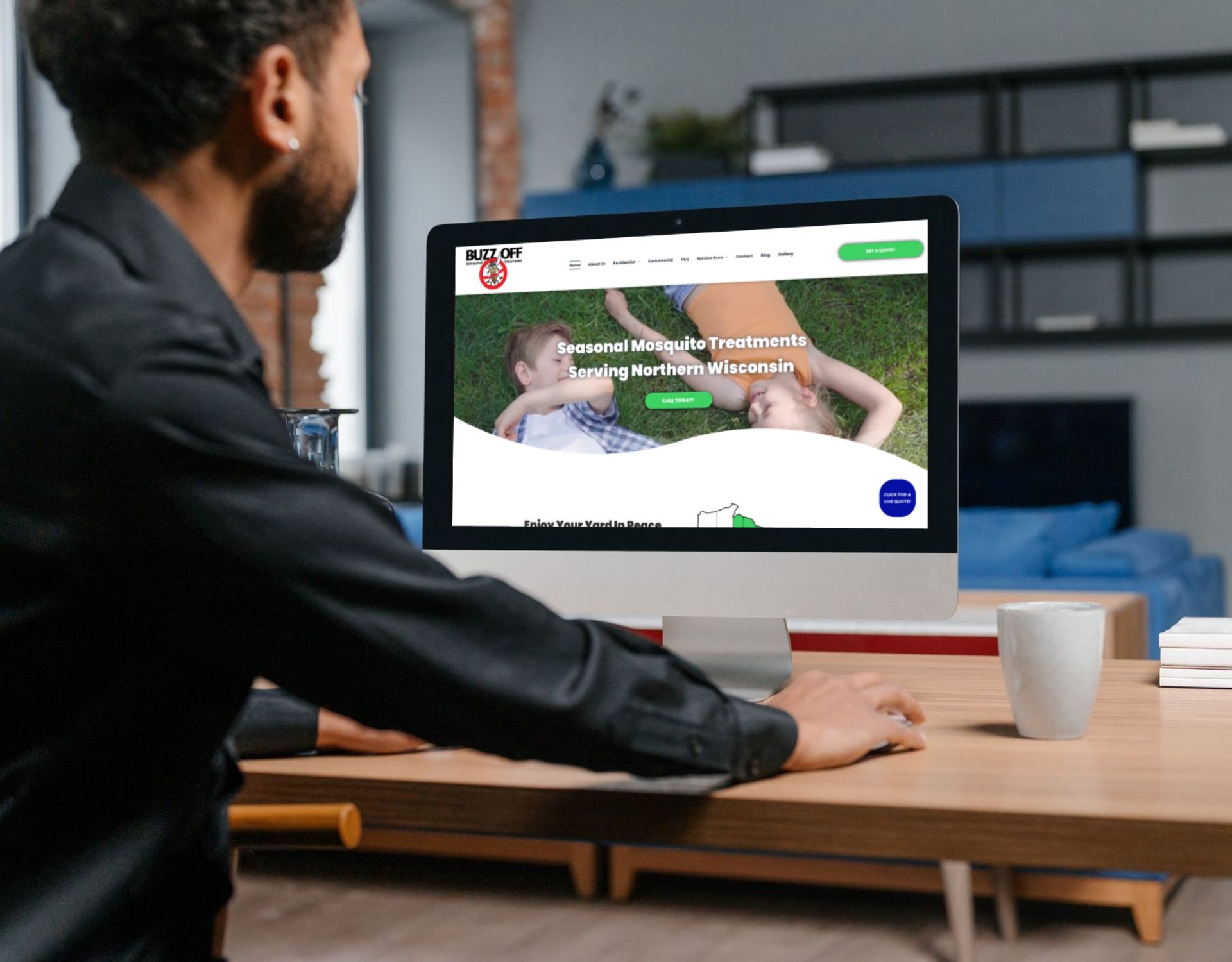 A man is sitting at a desk looking at a computer screen.