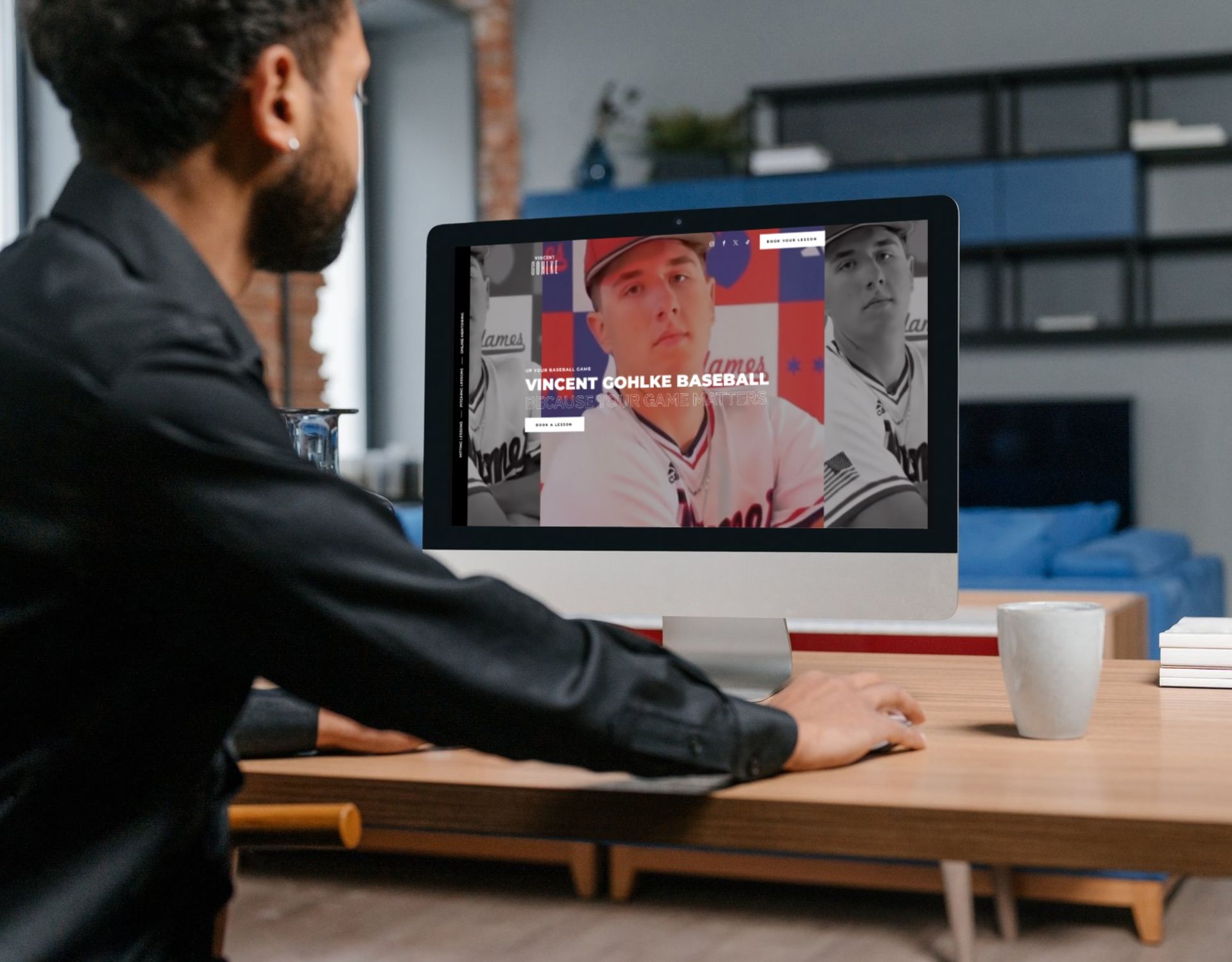 A man is sitting at a desk looking at a computer screen.