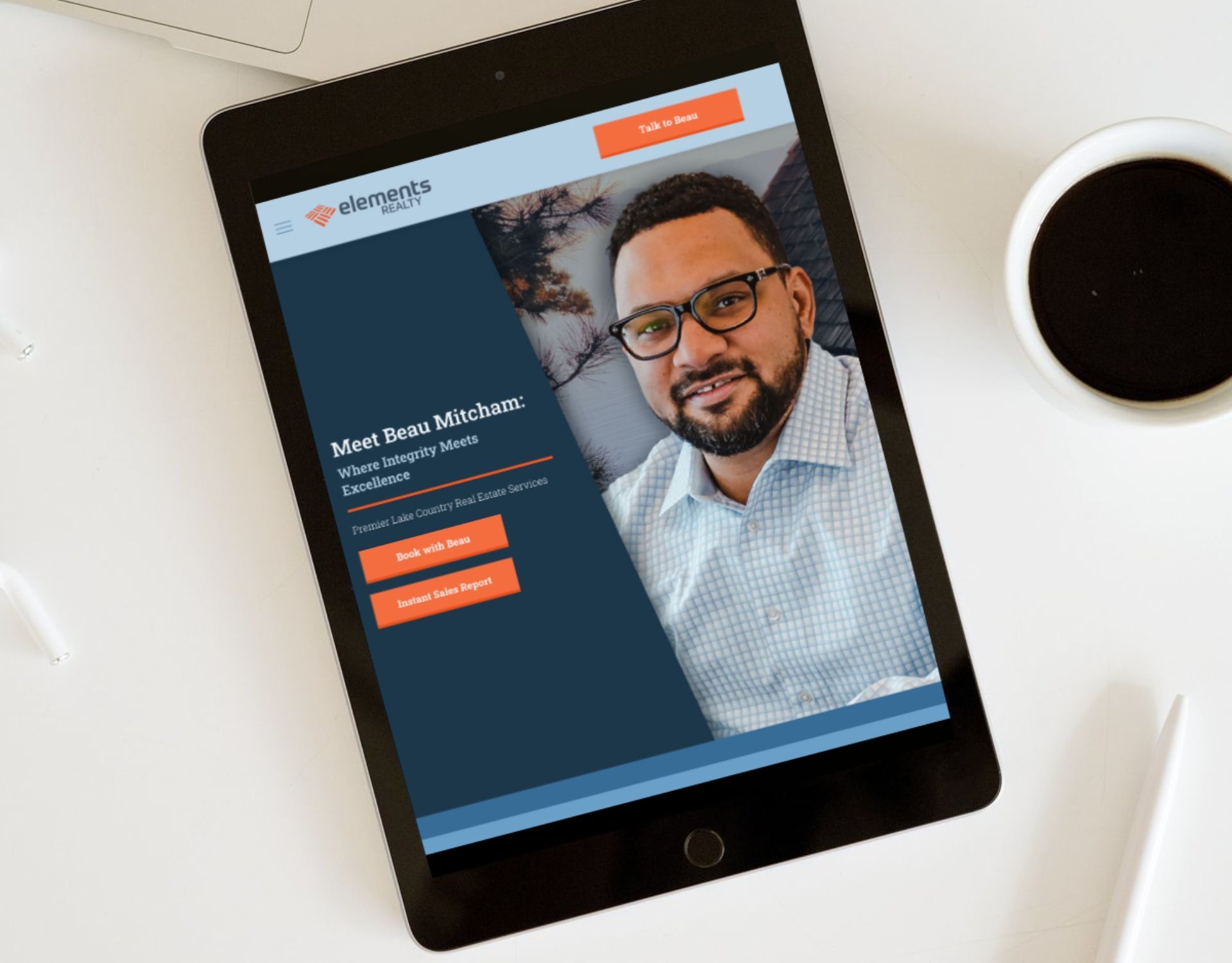 A tablet is sitting on a table next to a cup of coffee.