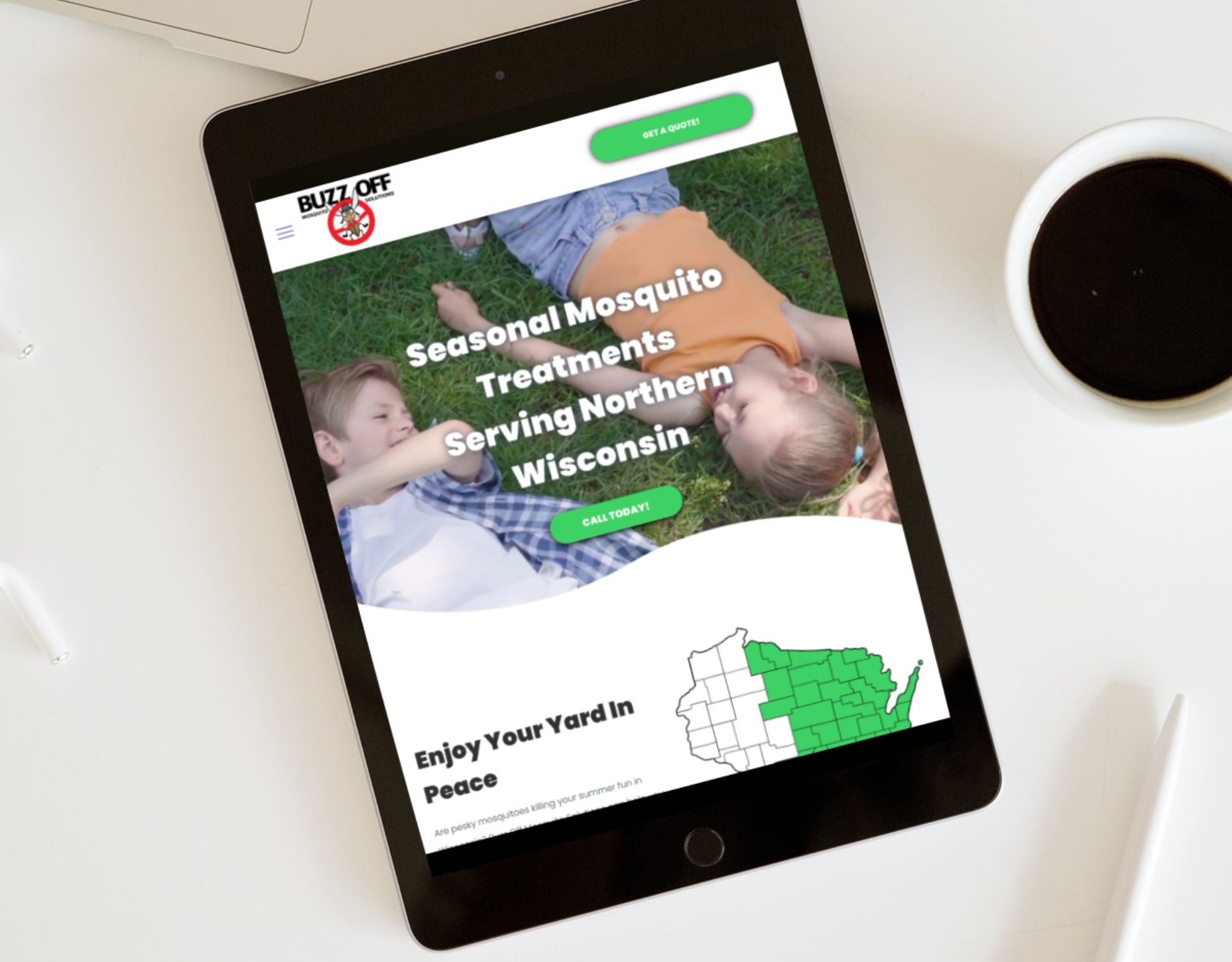 A tablet is sitting on a table next to a cup of coffee.