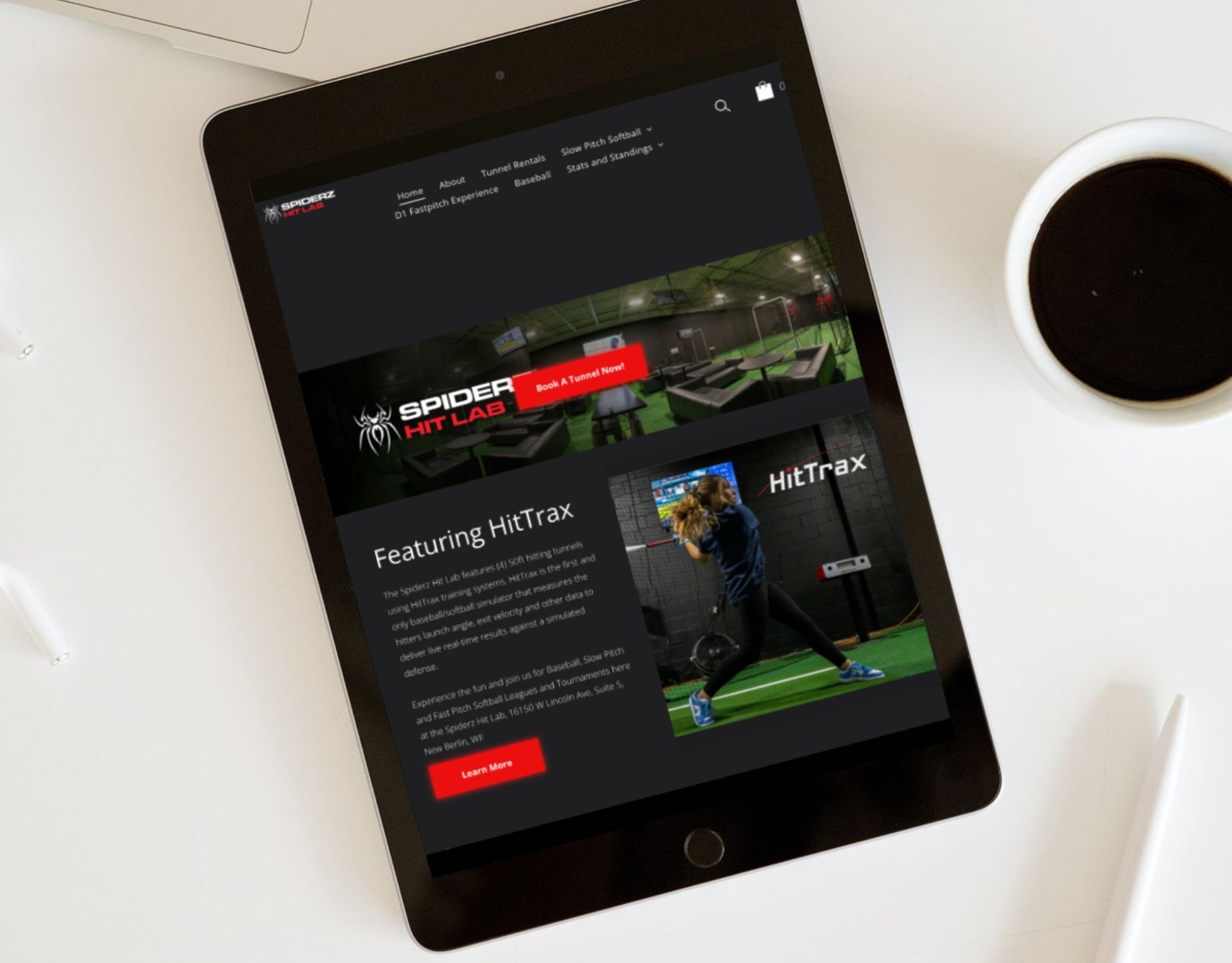 A tablet is sitting on a table next to a cup of coffee.