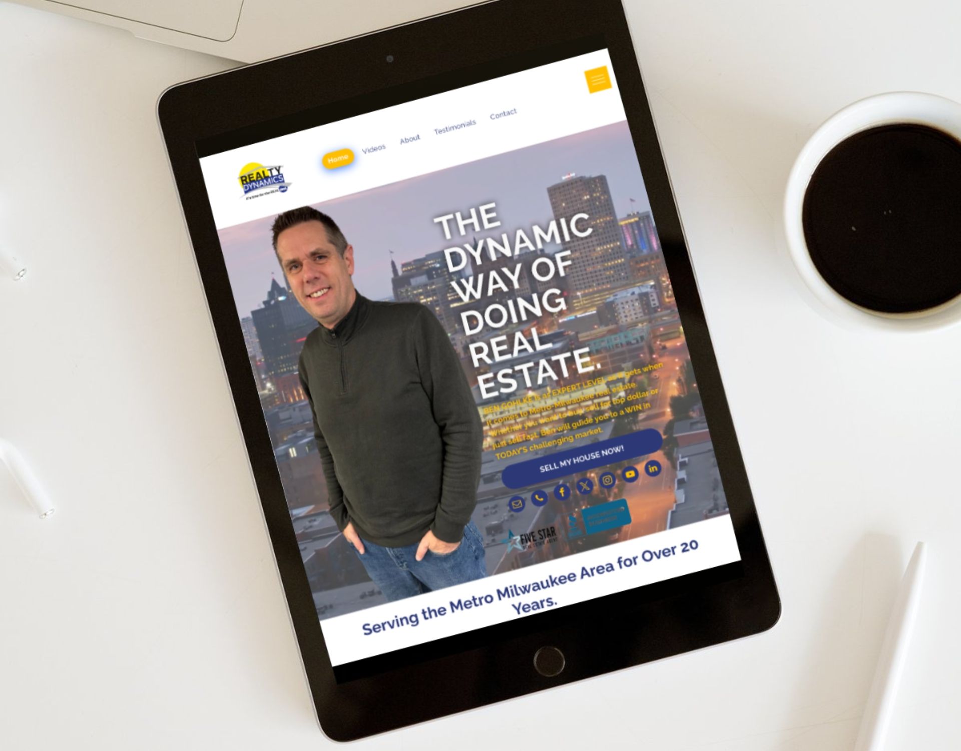 A tablet is sitting on a table next to a cup of coffee.