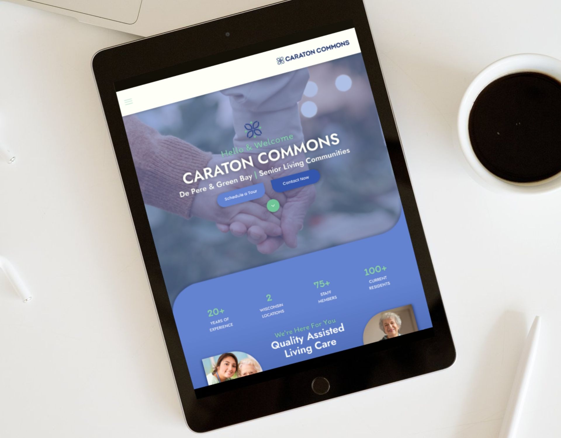 A tablet is sitting on a table next to a cup of coffee.