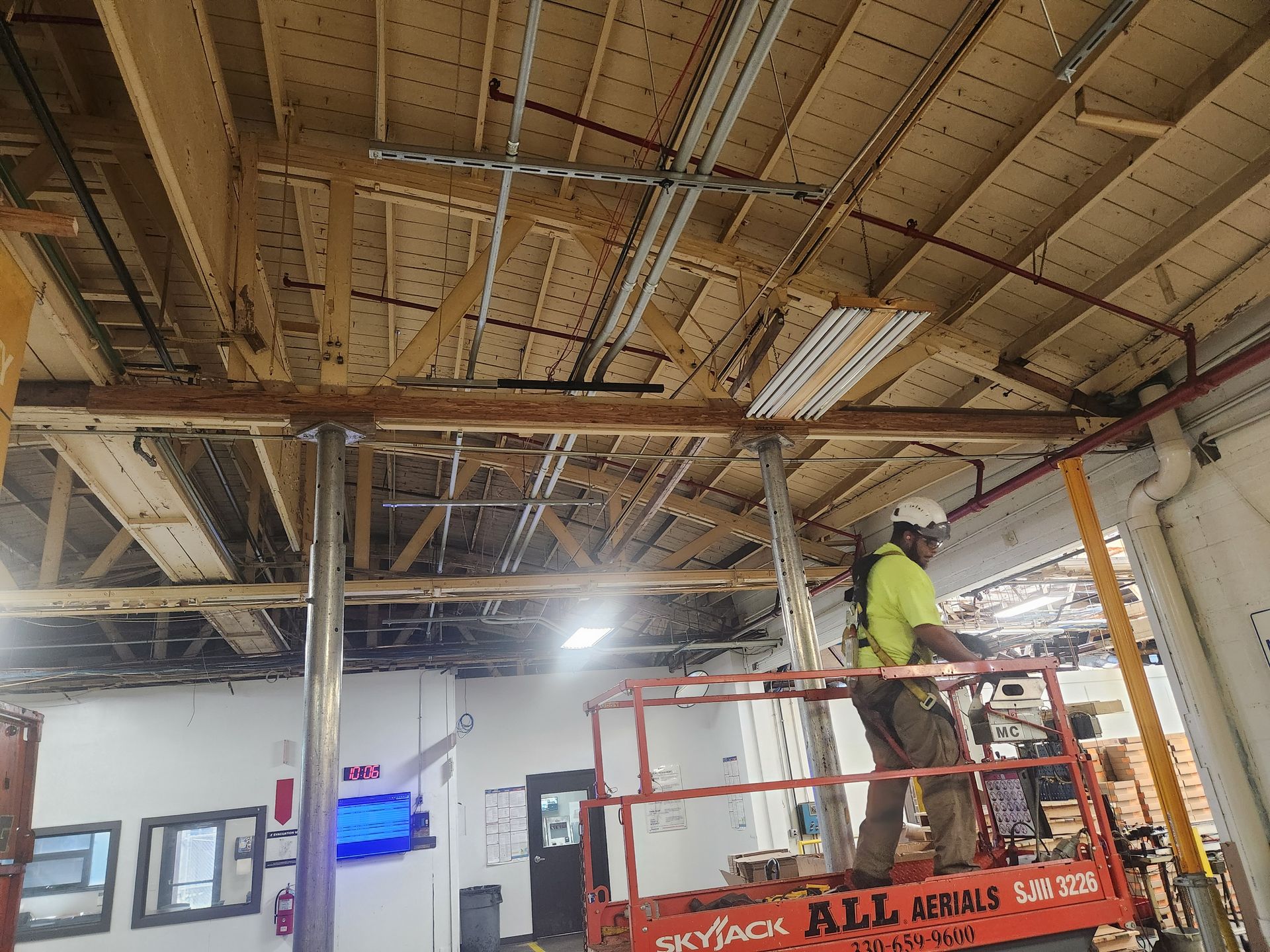A worker on a Skyjack lift repairing the bowstring truss roof in Fox Valley, IL, with safety gears