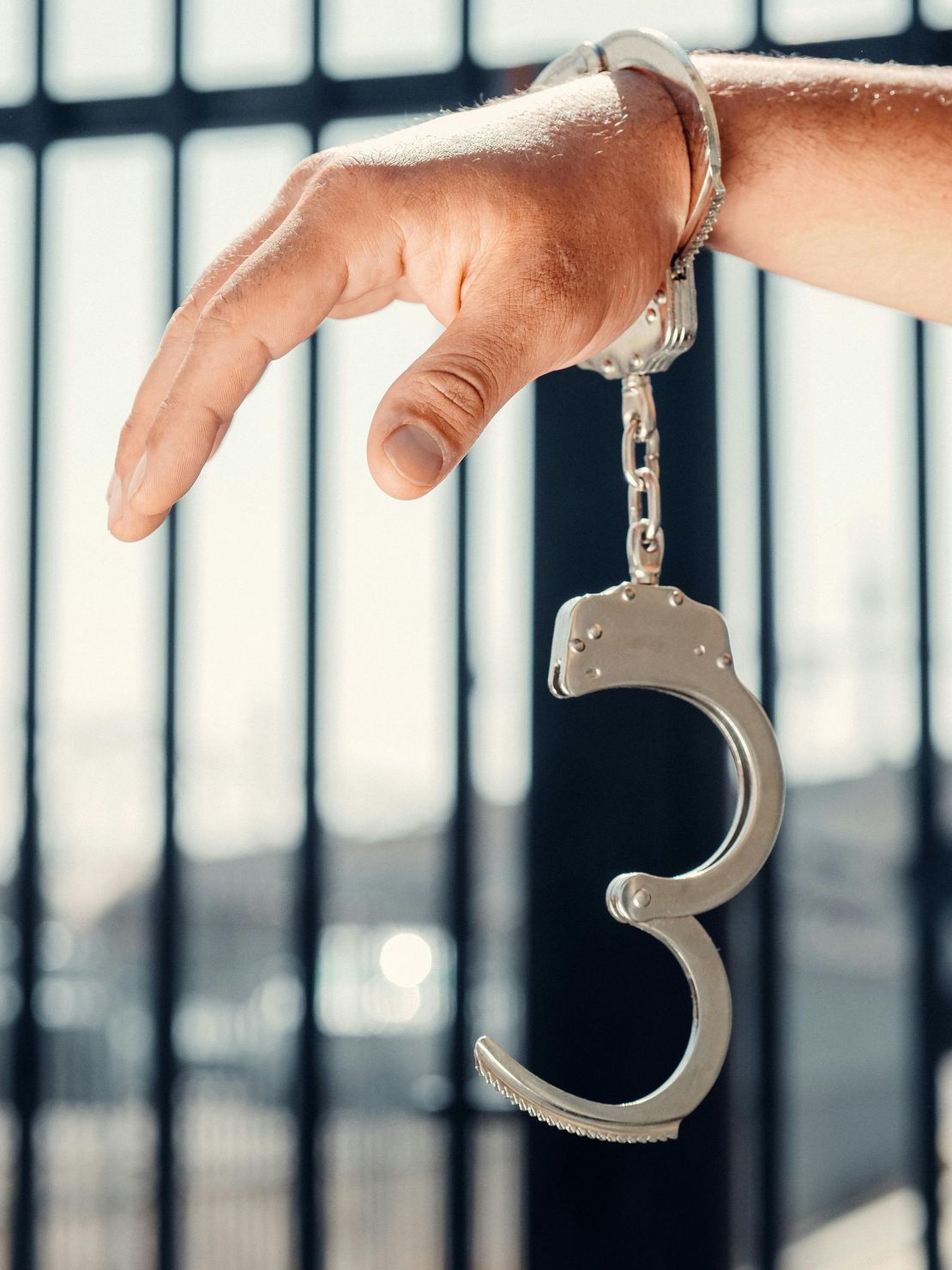 A person is wearing handcuffs with the number 3 on them.