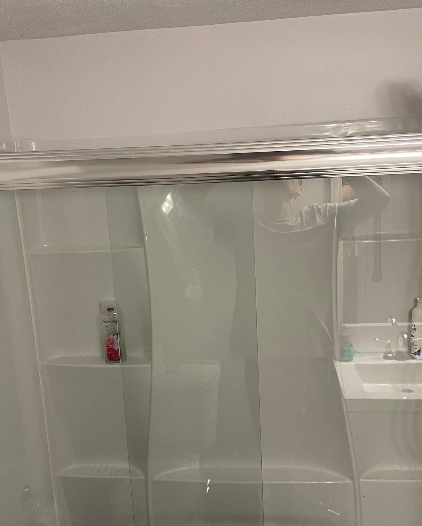 Clear shower curtain in a white bathroom, covering the shower stall.