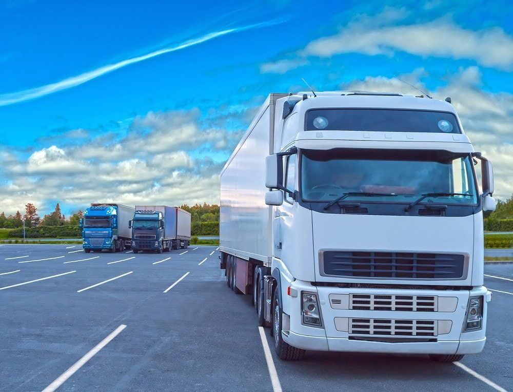 Three Semi Trucks Are Parked in a Parking Lot — FNQ Furniture Removals in Tablelands, QLD