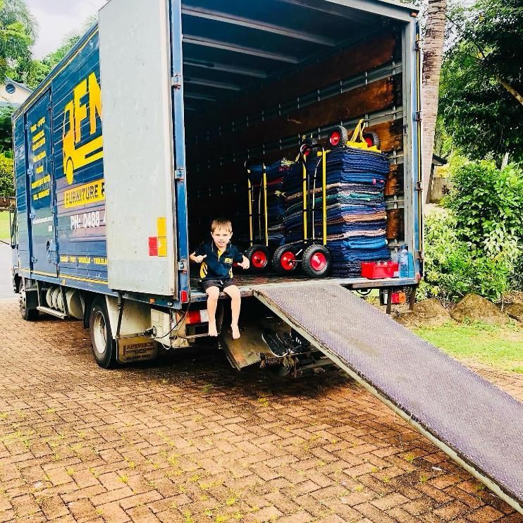 A Little Boy is Sitting on the Back of a Moving Truck — FNQ Furniture Removals in Tully, QLD