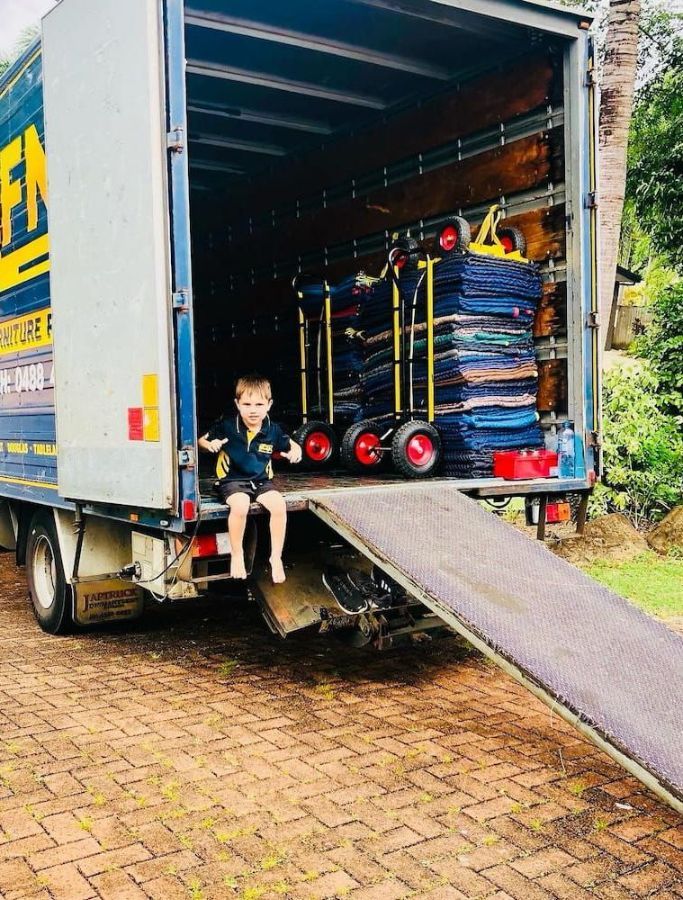 Two Men Are Loading Shelves Into a Van — FNQ Furniture Removals in Stratford, QLD