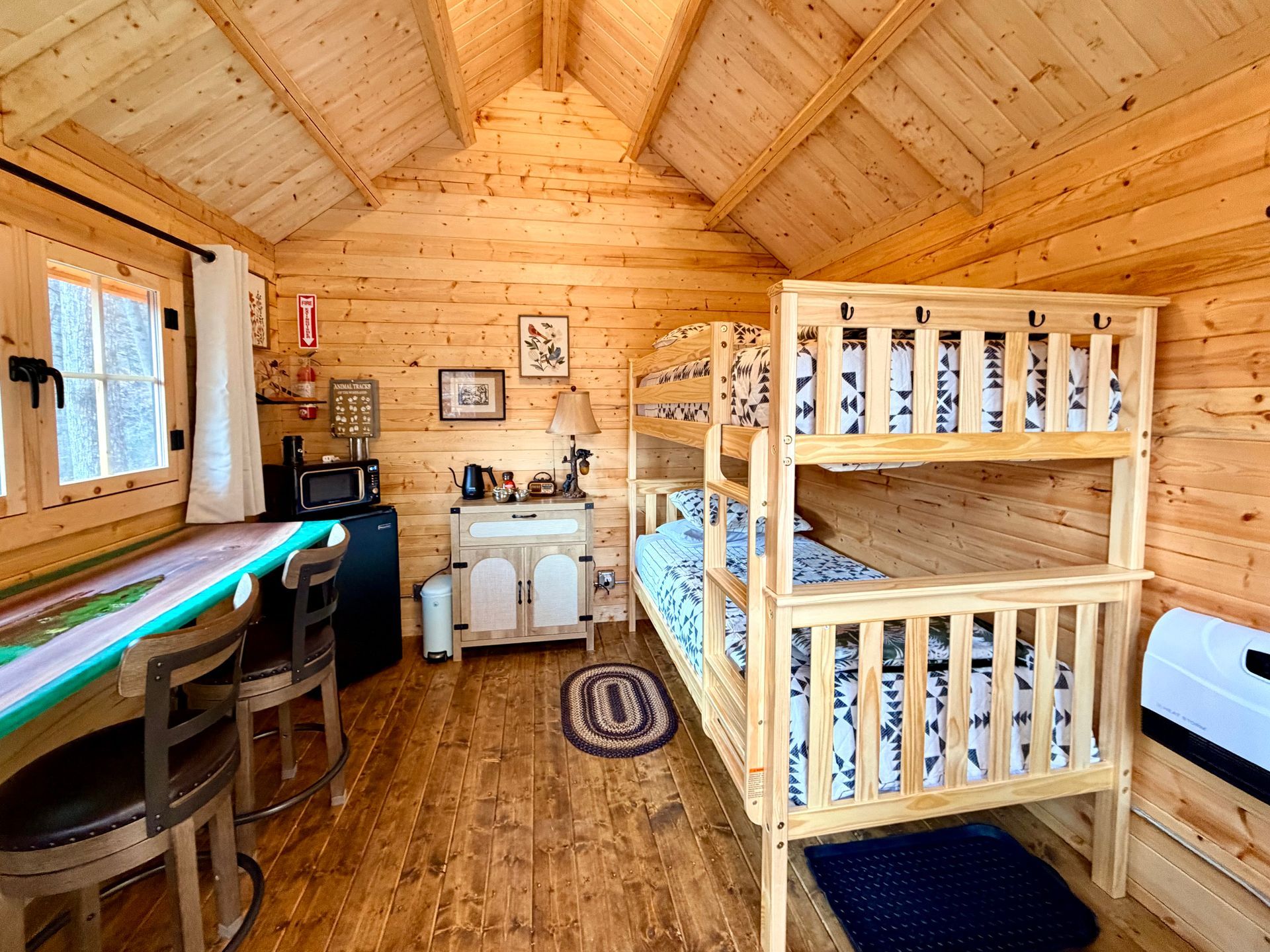 Cozy wooden cabin bedroom with bunk beds, desk, and warm natural light