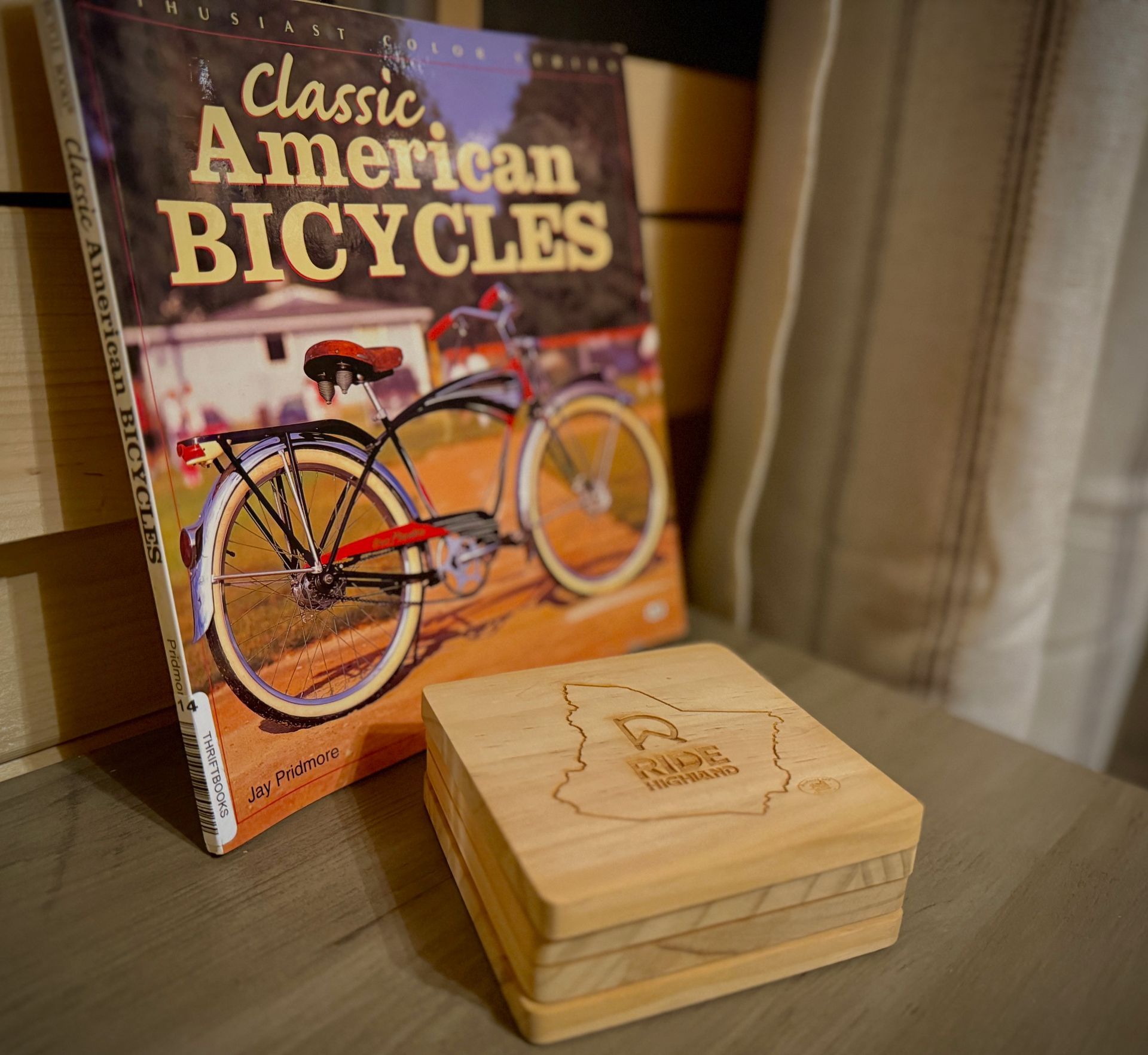 Classic American Bicycles book beside a small wooden box with a bicycle engraving on a table