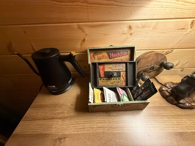 Wooden shelf with a black kettle, a tea organizer, and a decorative turtle on the right