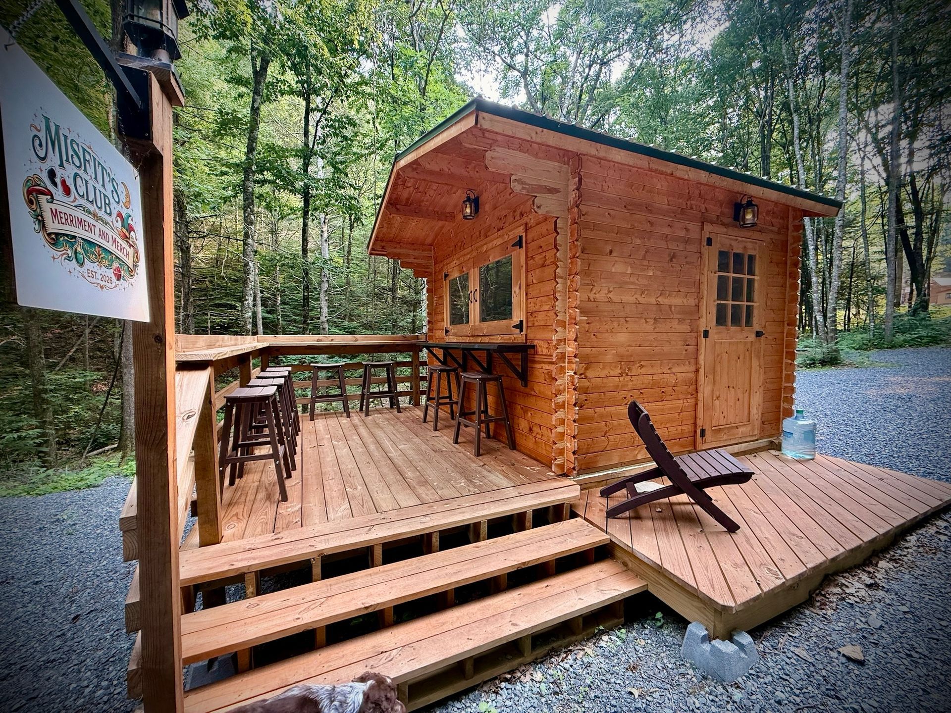 Wooden cabin deck with chairs and table in a forest campsite