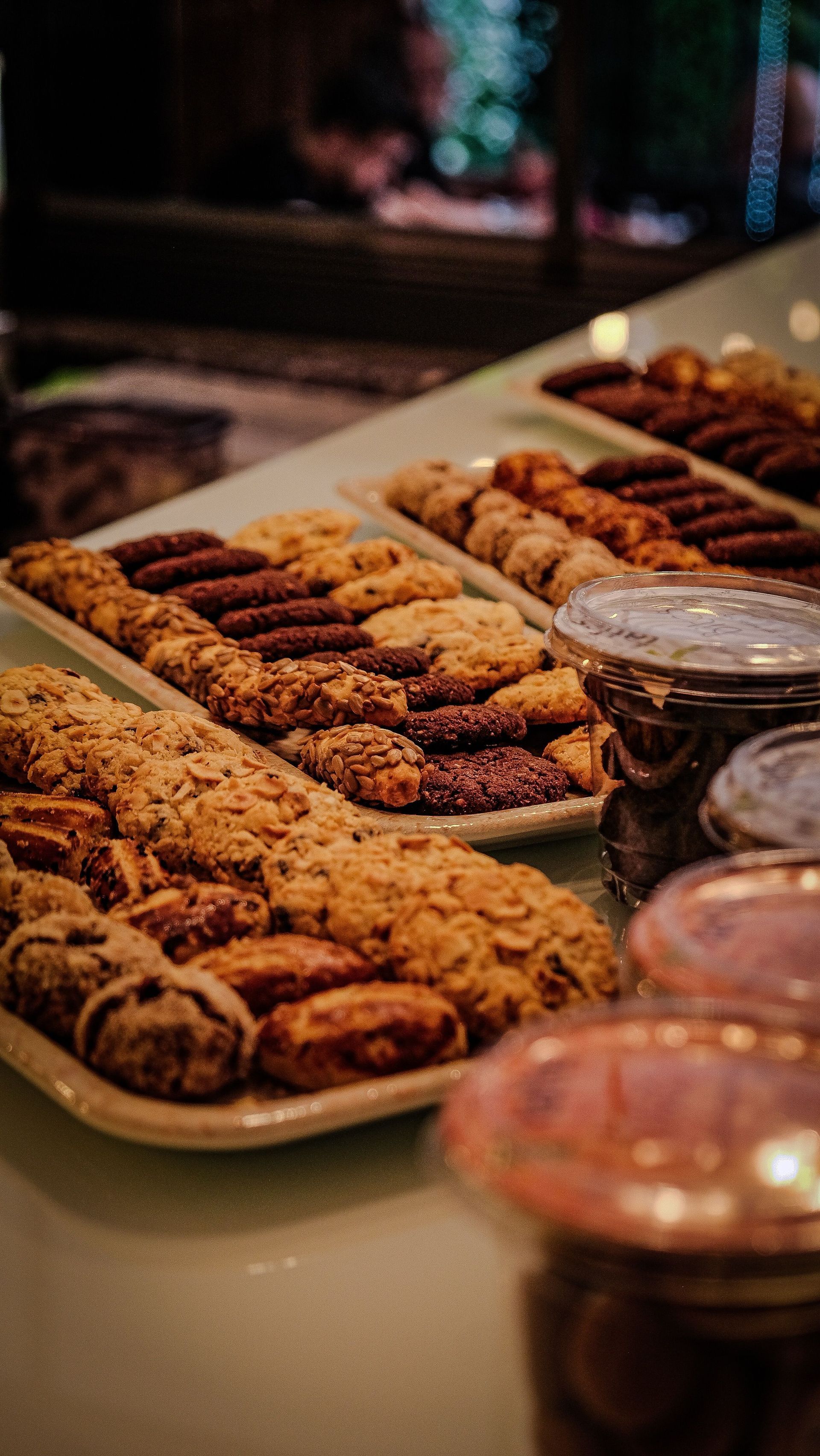 Tray of assorted pastries and cookies on a table, with tongs and bowls in the foreground.