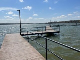 Wooden dock extending into a windy lake under a bright blue sky
