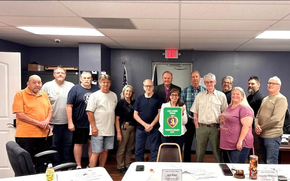 Log Cabin Council and staff pose for picture with representatives from Caring for America in Henderson County and Veterans with new Log Cabin Purple Heart Sign