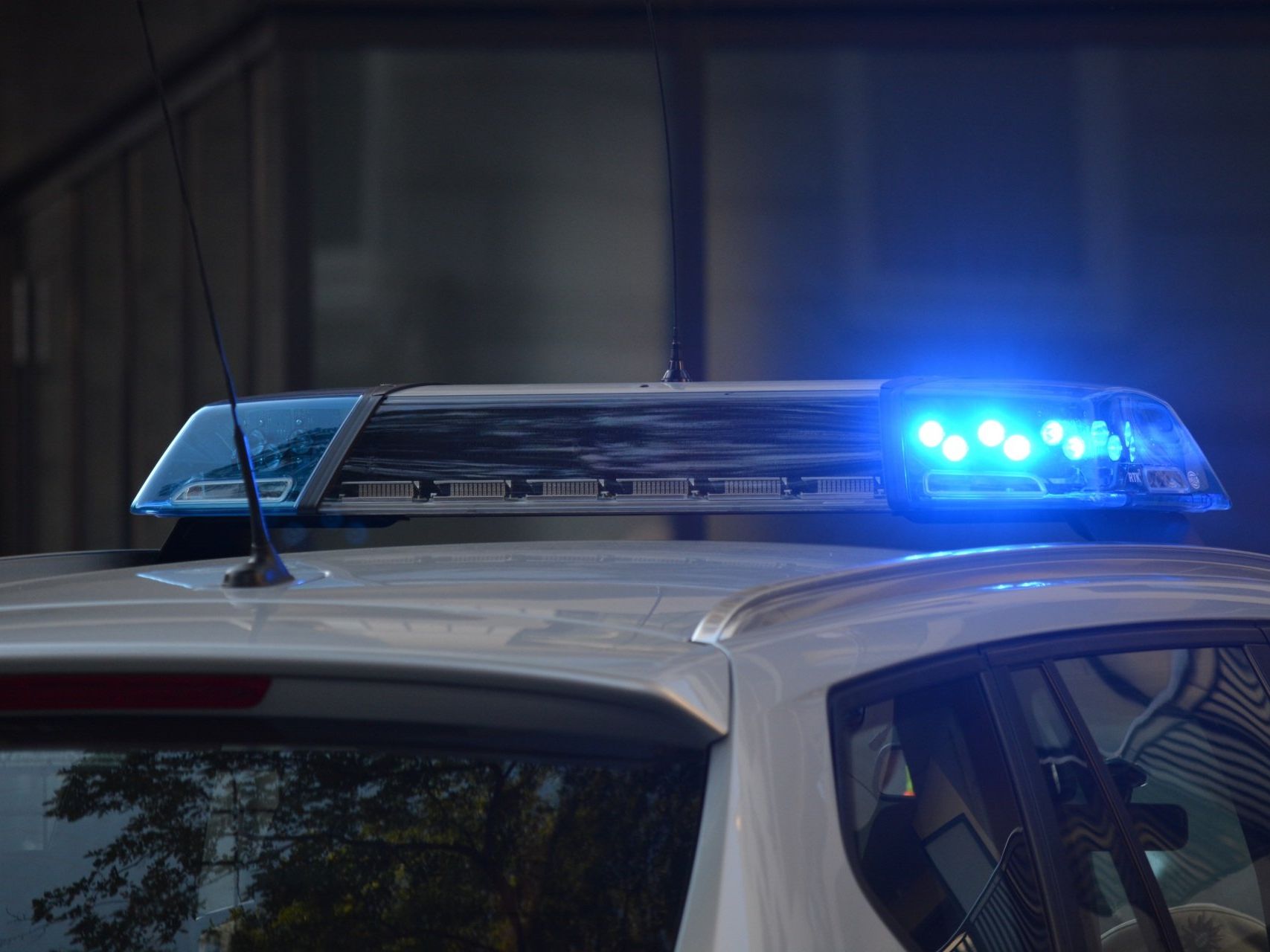 Police car roof with blue emergency lights flashing at night