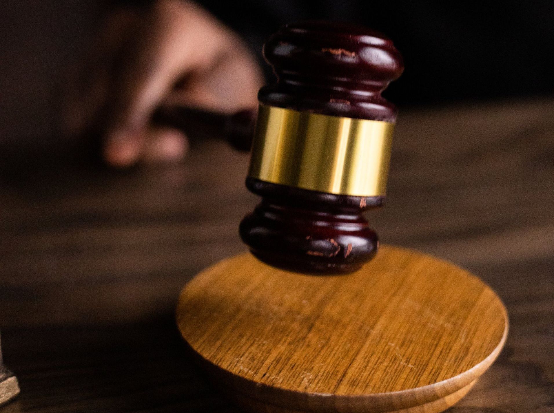 Judge’s gavel hovering above a wooden block on a desk