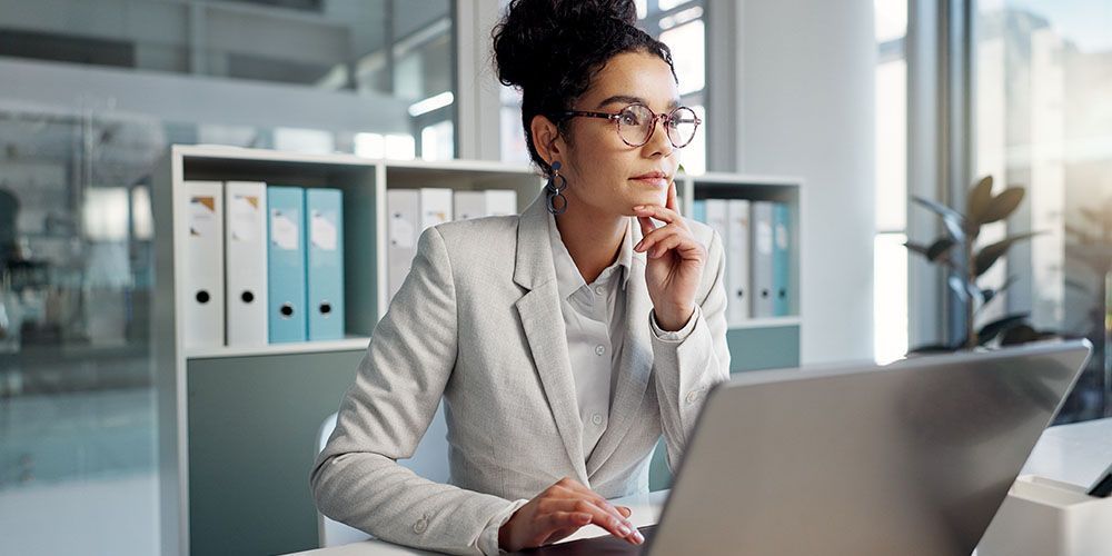 mujer consultando computadora en un banco