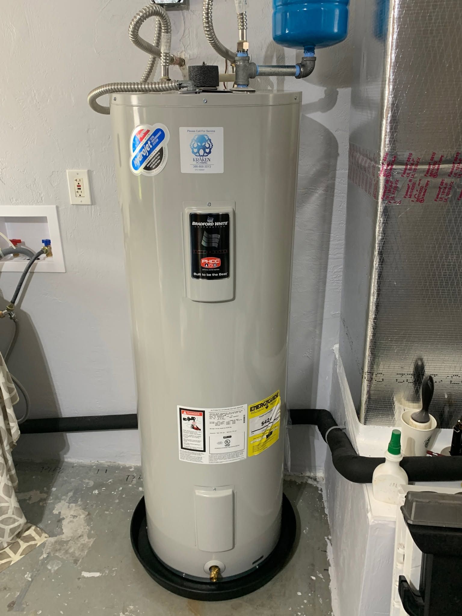White water heater with digital display and blue tank in a utility room.