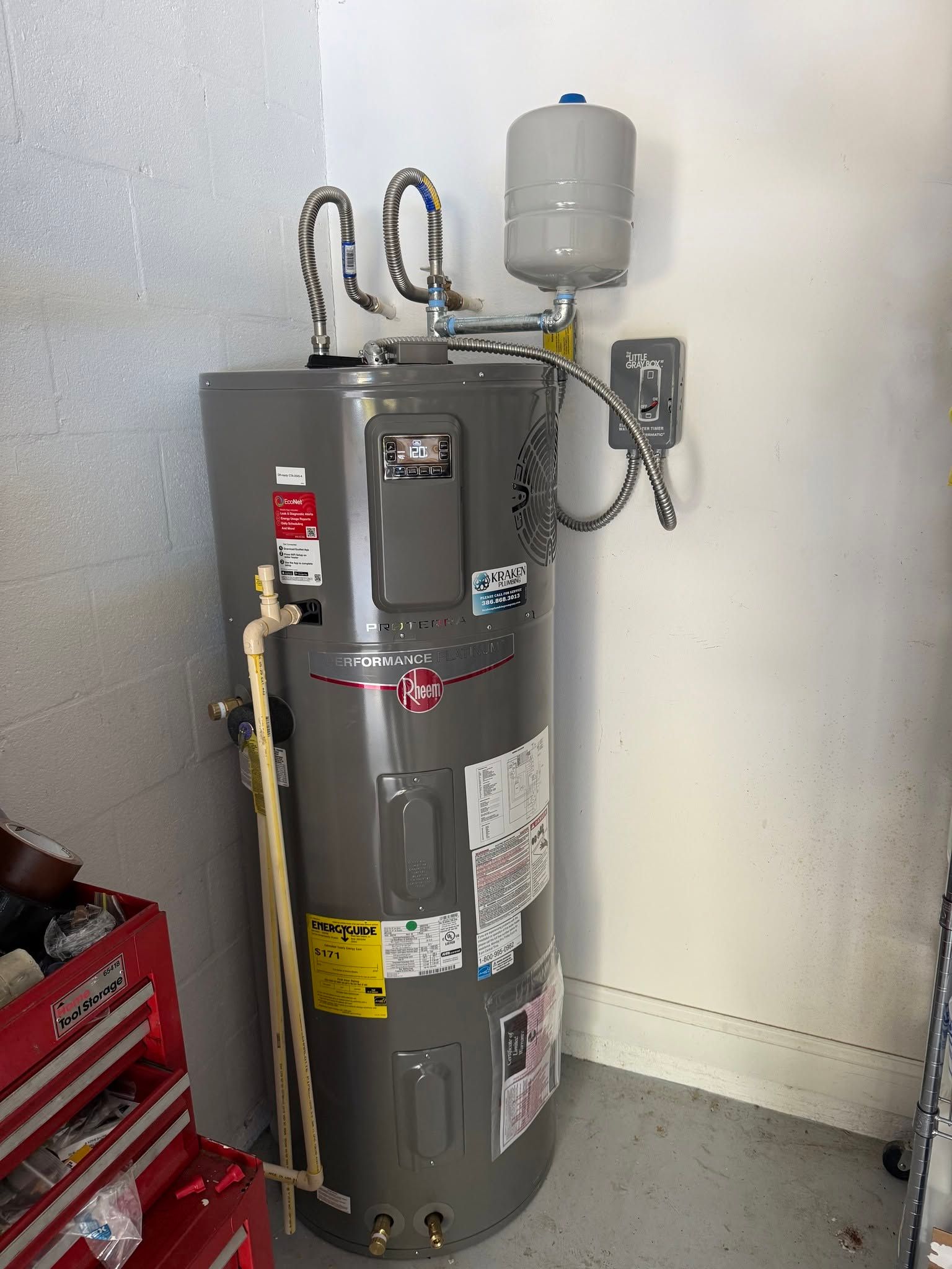 Gray water heater with expansion tank and pipes in a utility room corner
