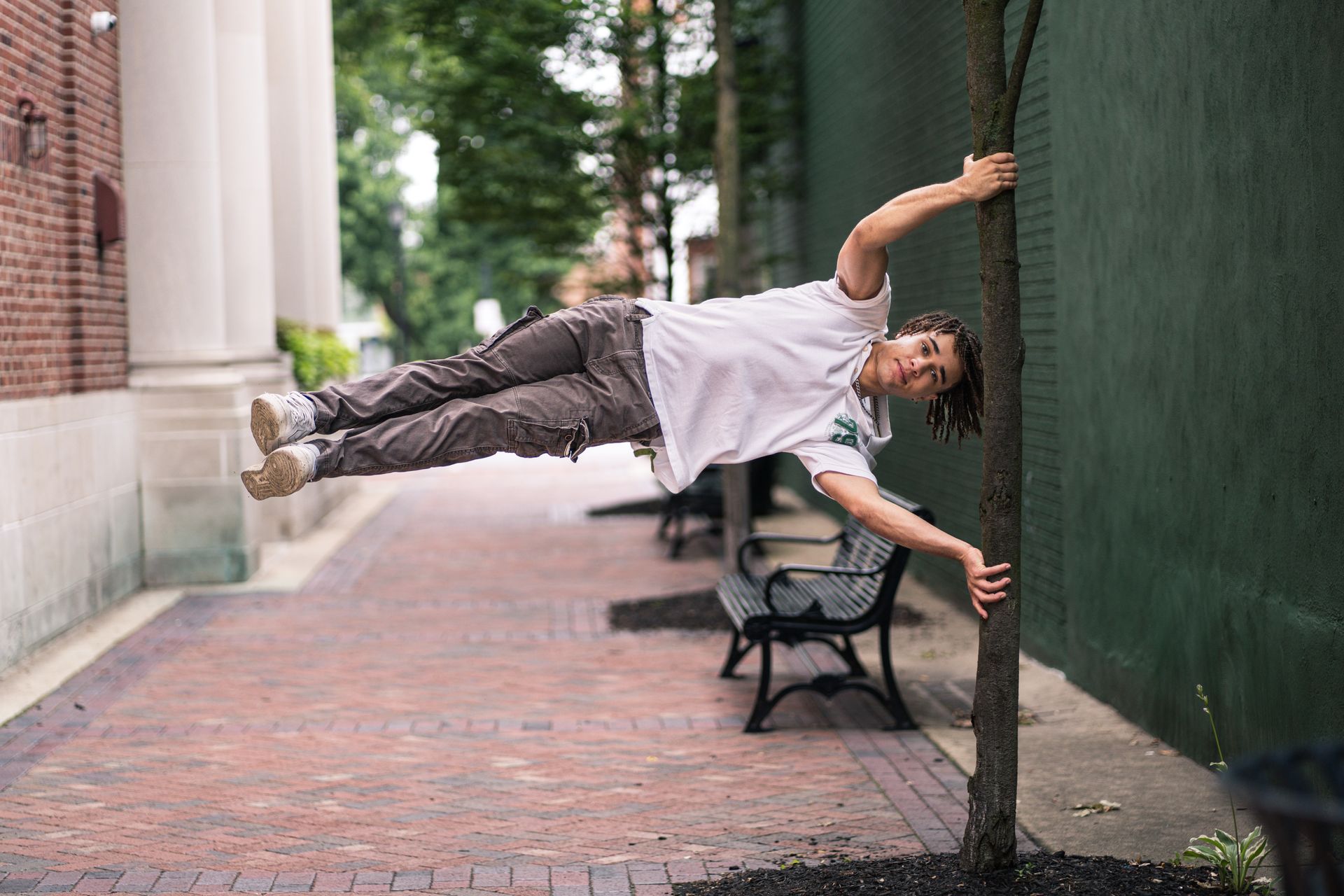 A man is doing a handstand on a tree.