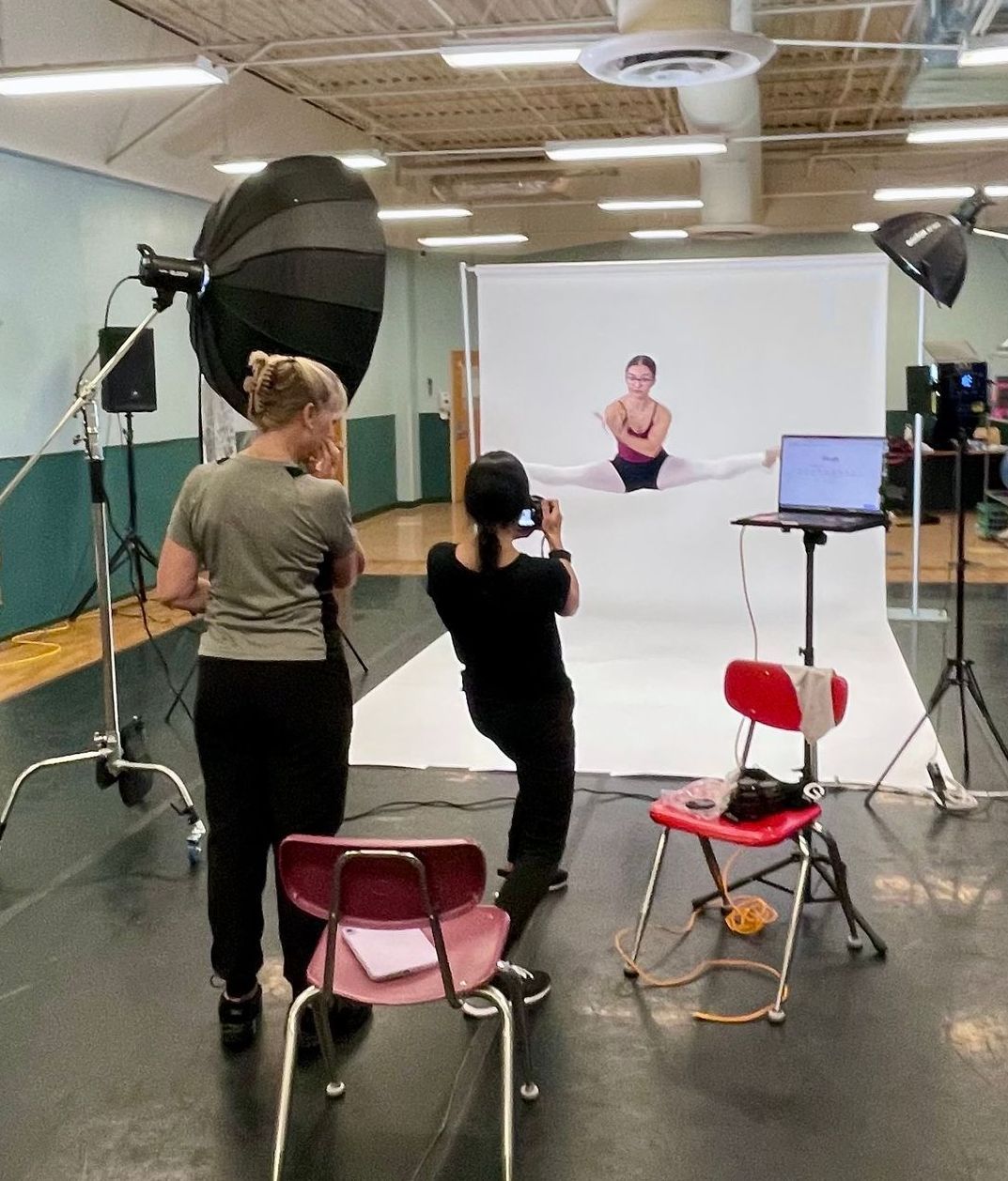 A woman is taking a picture of a woman doing splits
