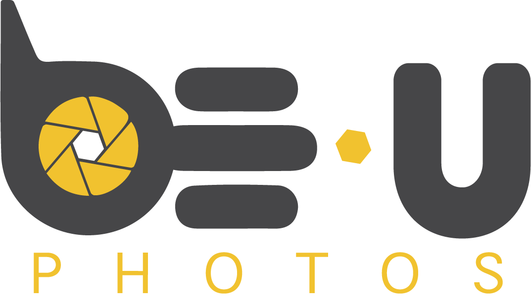 Logo for BEU Photos, gray with yellow accents: a camera lens integrated into the letters "BE" and a stylized "U."