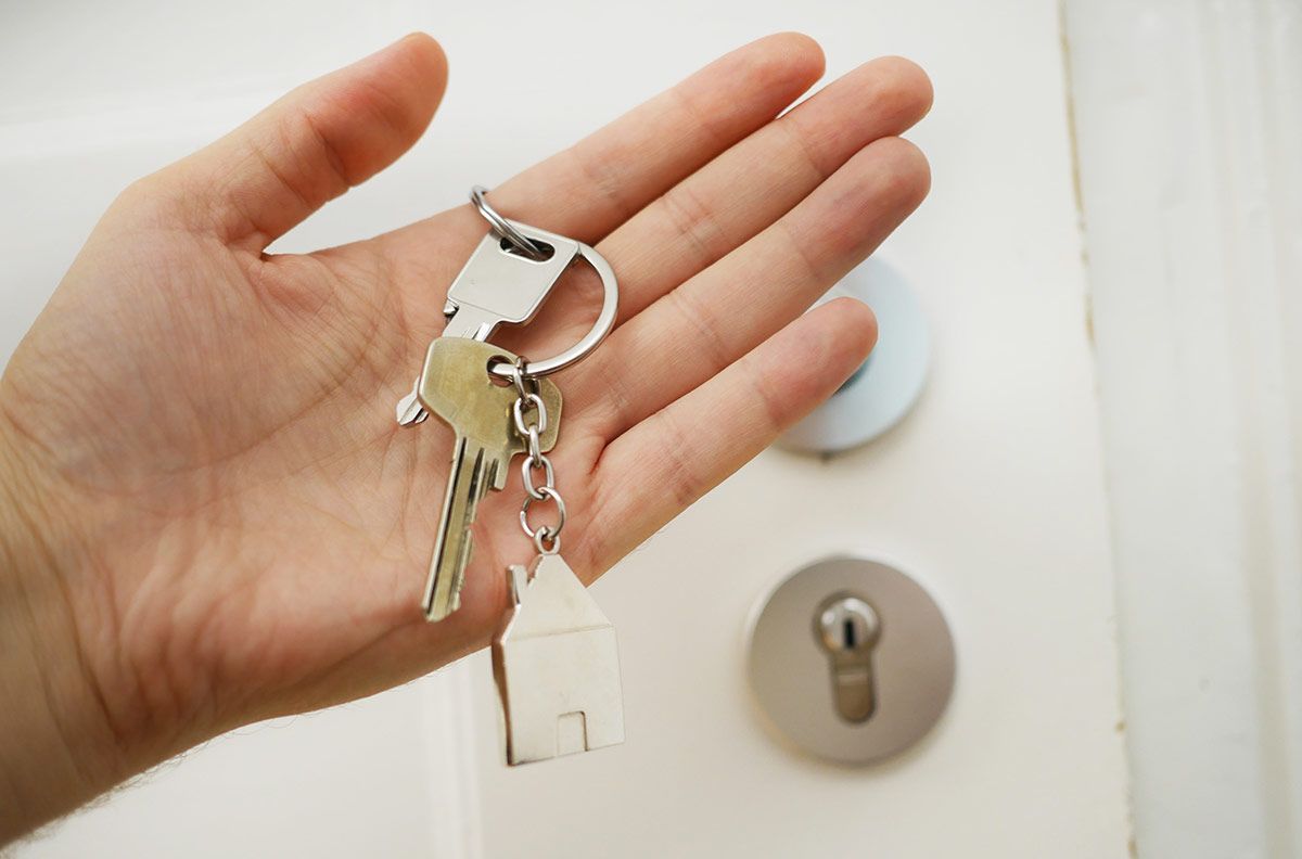 Before handing over the keys, it's important to do thorough tenant screening. Phot of hand holing keys to an apartment