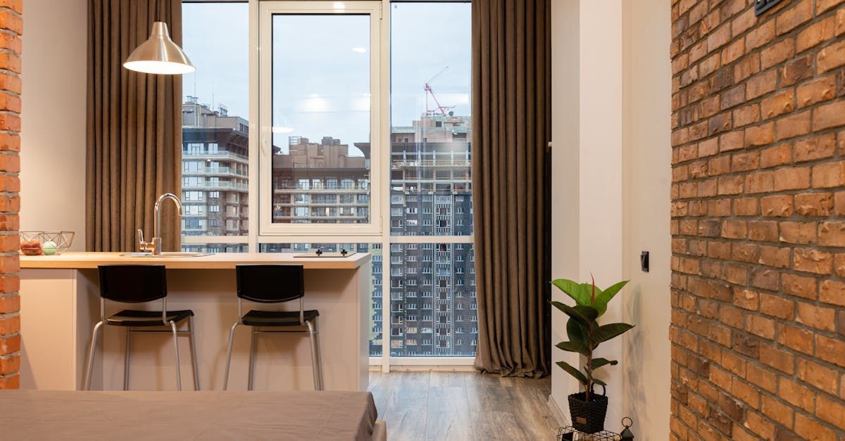 A living room with a brick wall and a large window.