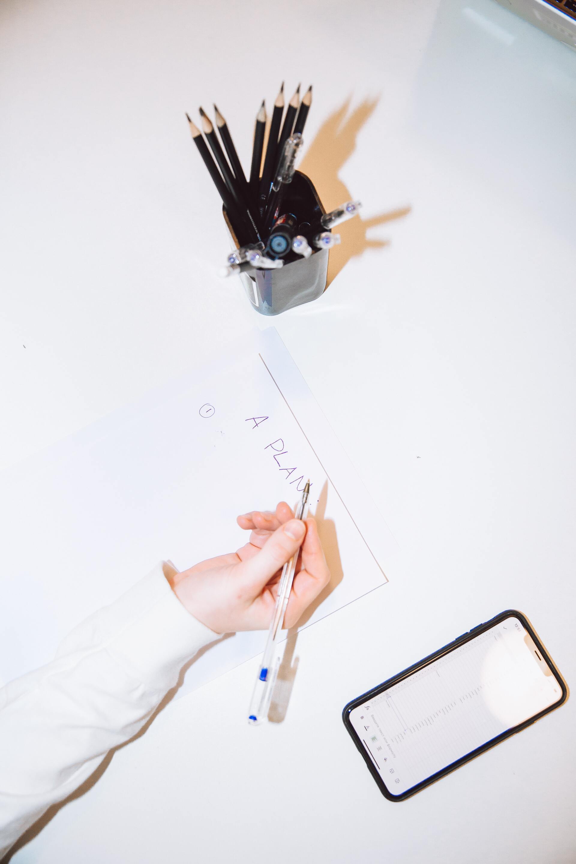 A woman starting to write down her funeral plans.
