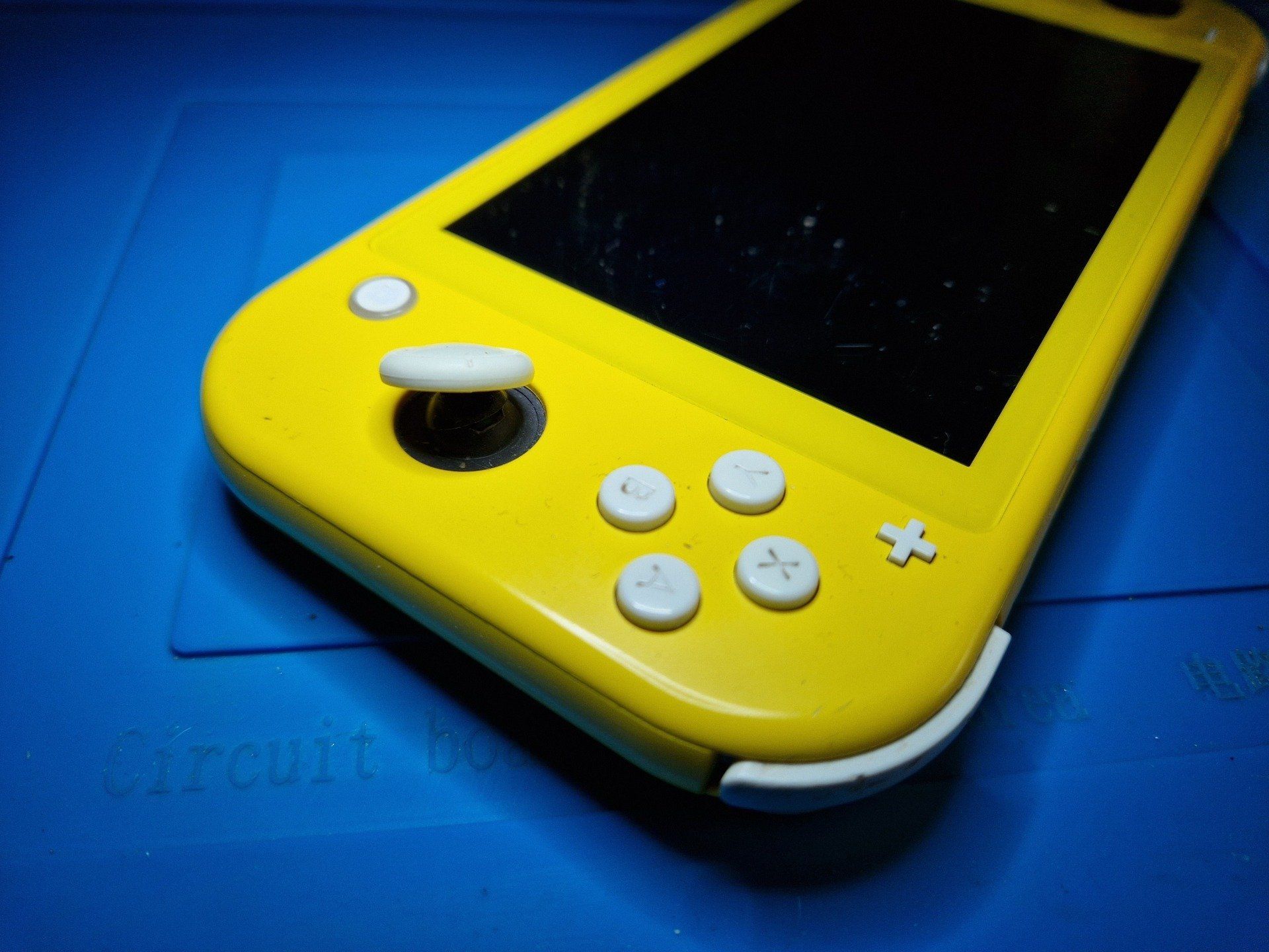 Een gele nintendo switch ligt op een blauwe mat