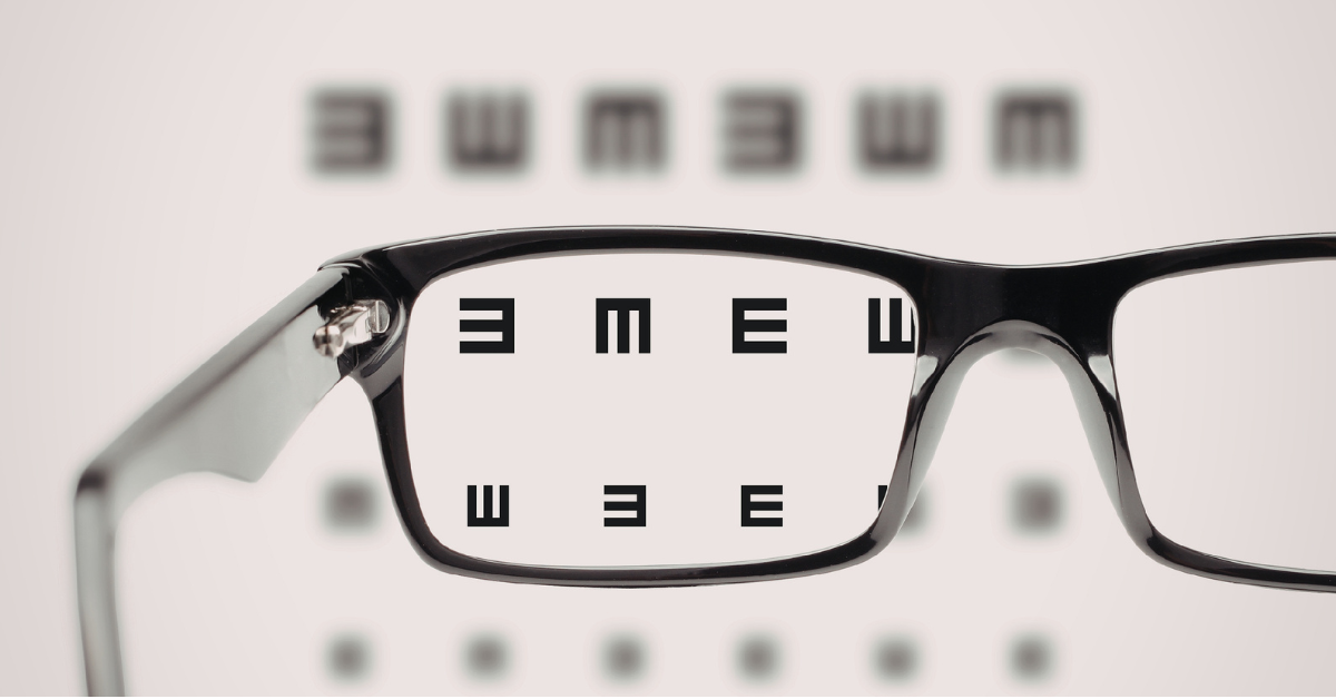 Eyeglasses on an eye chart, with letters magnified through the lens to symbolise career transition for lawyers