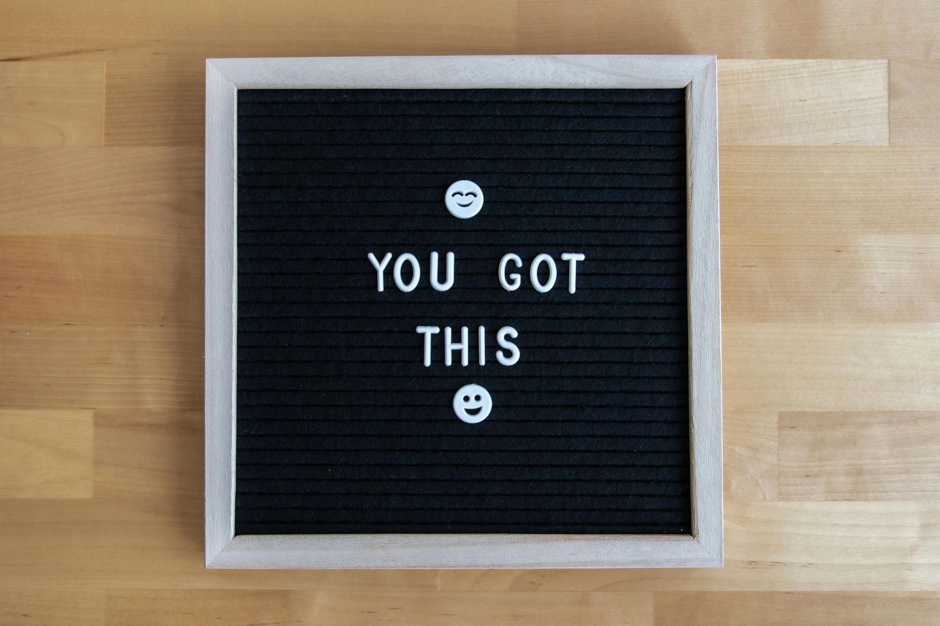 Black letter board on a wooden table reads “YOU GOT THIS” with small smiley faces encouraging behavioural interview playbook