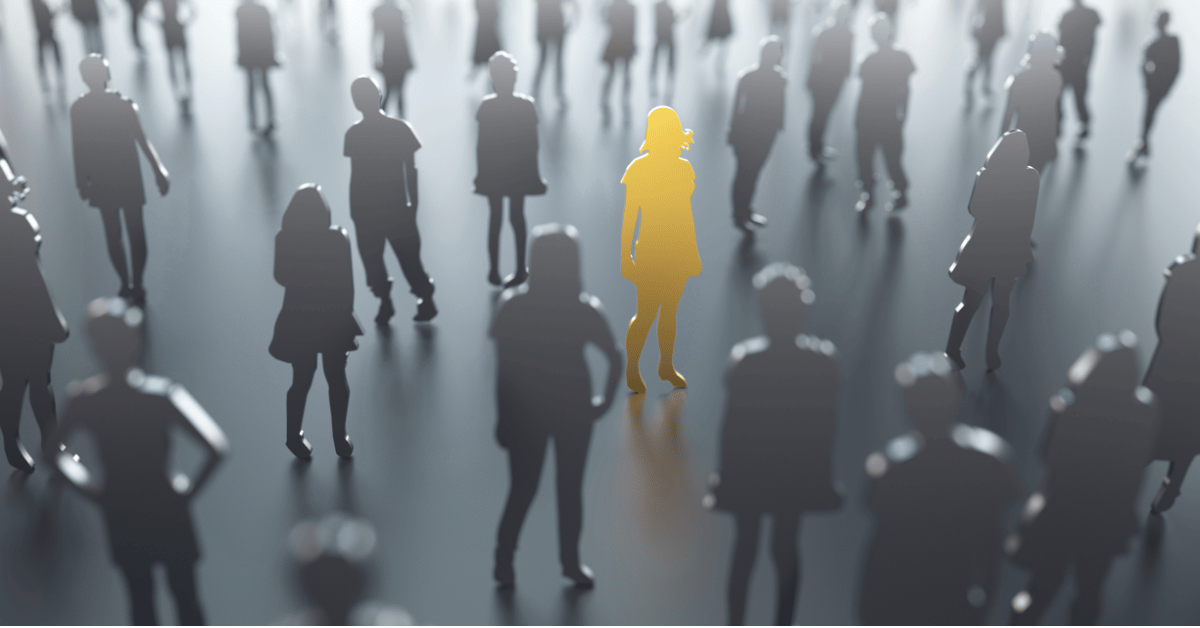Crowd of people in grayscale with one highlighted yellow figure standing out in the center
